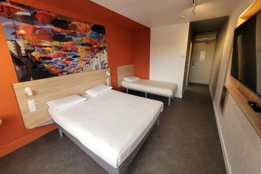 A family room for a couple and child at Kyriad Direct Dardilly hotel, north of Lyon