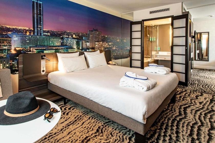 Dans Hôtel Novotel Paris Porte d’Orléans, une chambre double avec un mur tapissé d’un panorama de Paris