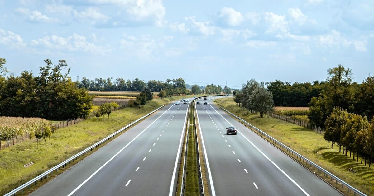 A motorway in the countryside, seen from a bridge on a summer’s day
