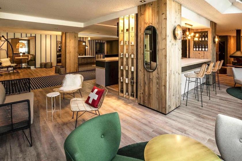 Le hall d’accueil de l’hôtel Mercure au centre de Chambéry avec ses boiseries modernes et fauteuils colorés