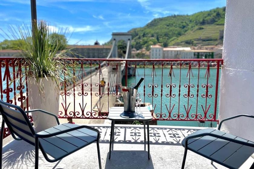 Le balcon d’une des chambres de l’hôtel Les Deux Coteaux, donnant sur la passerelle piétonne traversant le Rhône