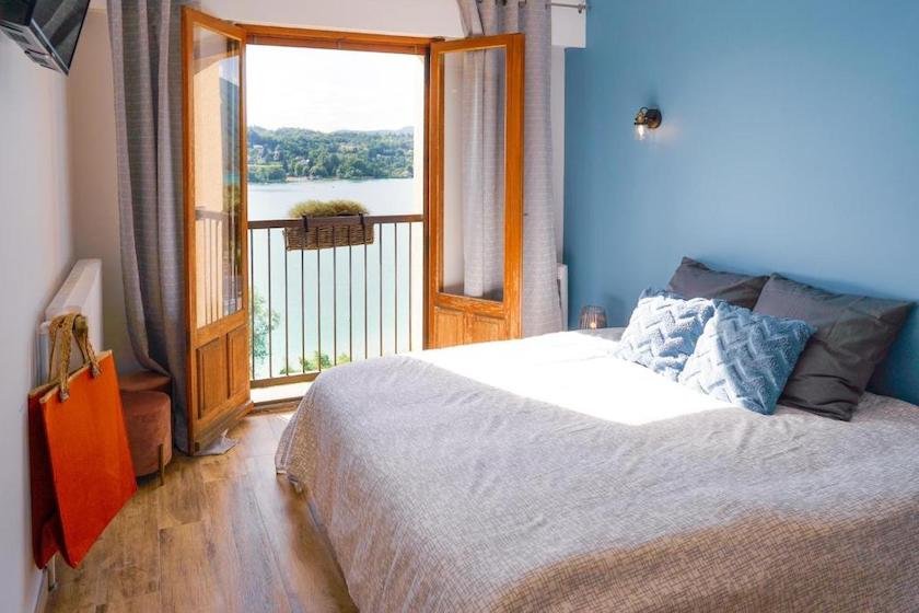 L’une des chambres de l’hôtel Aquabella, la porte vitrée ouverte sur le balcon donnant sur le lac