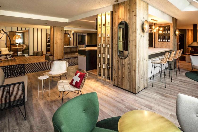 Le hall d’accueil de l’hôtel Mercure au centre de Chambéry avec ses boiseries modernes et fauteuils colorés