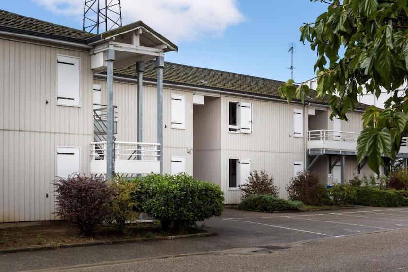 La façade extérieure de l’hôtel Initial by balladins, vue depuis son parking