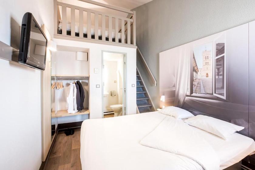 One of the triple rooms at B&B Hotel Valence Nord, with a mezzanine bed above the bathroom area.