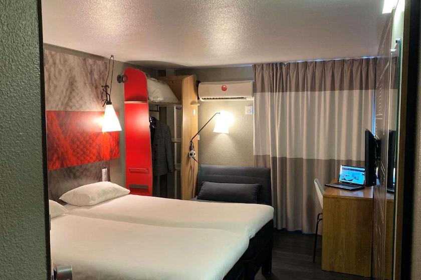 Une chambre twin, rideaux fermés de l’hôtel Ibis Lyon Sud Chasse-sur-Rhône