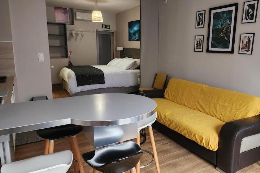 L’un des appartements de l’Appart’Hotel du Cloître montrant l’espace nuit et l’espace jour avec la kitchenette.